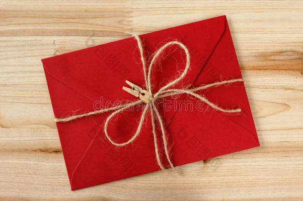 红色的信封系和黄麻纤维盘绕和晒衣绳上夹衣服<strong>之</strong>夹子向一木制的b一c