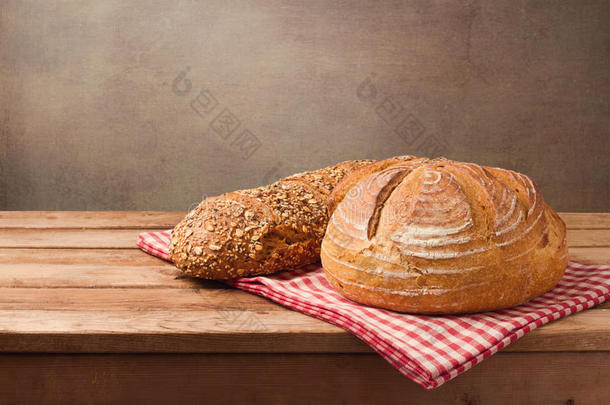 烘烤制作的面包向木制的表越过乡村的背景