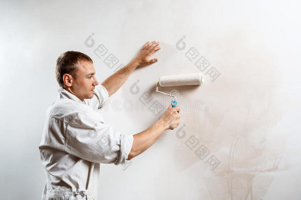 工人绘画墙和滚筒采用白色的颜色.复制品空间.