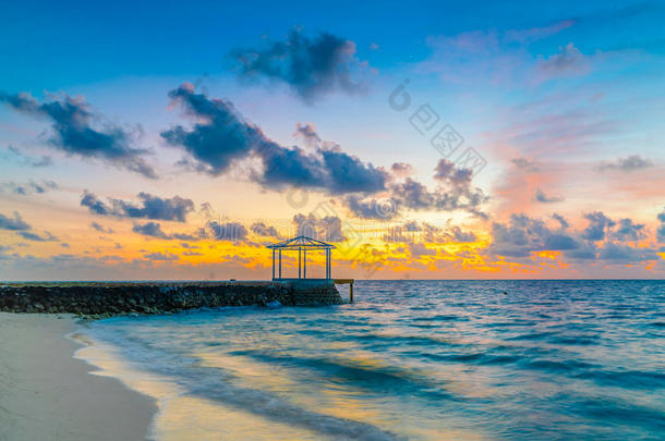 美丽的日落和天越过镇定的海采用热带的马尔代夫是（be的三单形式