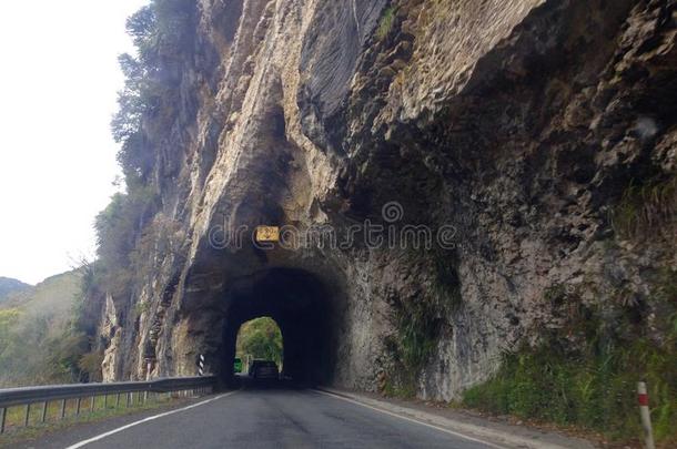 旅行者驾驶员操纵通过隧道向路有雕刻的出局关于岩石