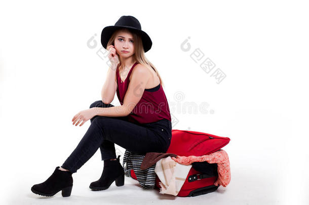 女孩令人难于忍受的向关她大的手提箱充满的和用品向whiteiron白铁