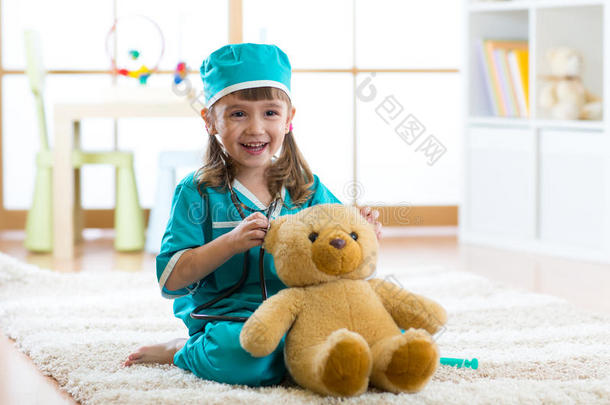 漂亮的小孩女孩演奏医生和豪华的玩具在家