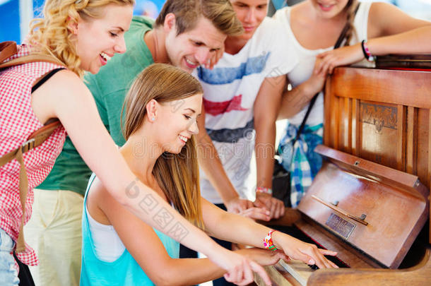 少年男女在夏音乐节日,女孩演奏指已提到的人钢琴