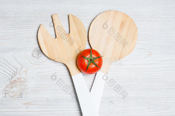 番茄和木制的餐具向白色的木制的背景