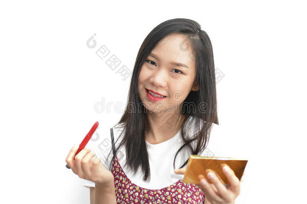 亚洲人女人应用红色的口红和化妆品铅笔
