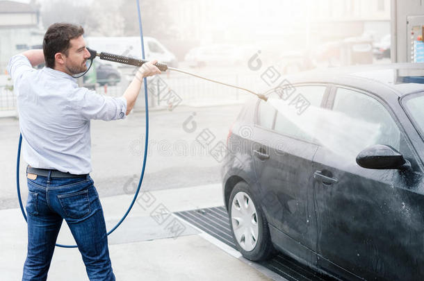 男人洗涤汽车采用汽车洗车站