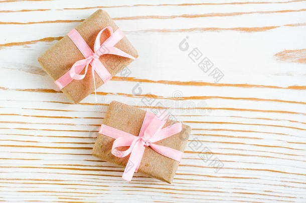 两个成套赠品和一粉红色的带向一白色的木制的b一ckgroun