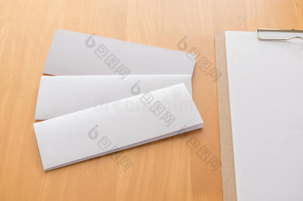 num.四折叠白色的样板纸和木制的有纸夹的笔记板向木材用绳子拖的平底渡船