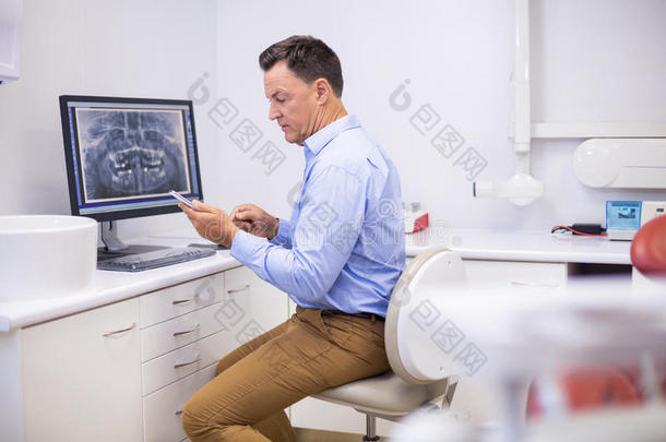 肖像关于幸福的牙科医生使用可移动的电话