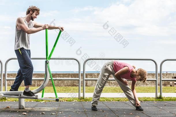 男人锻炼向椭圆的运动鞋和女人.