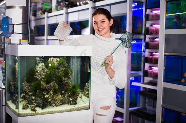 女孩是（be的三单形式遵守水族馆网和水容器紧接在后的向水族馆