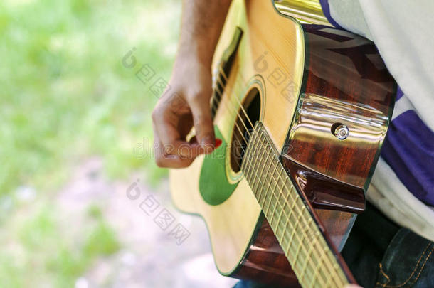年幼的吉他演员演奏歌曲户外的采用公园