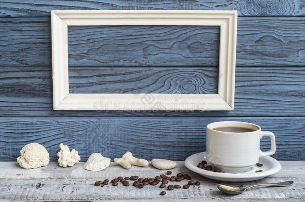 白色的框架,咖啡豆杯子和壳向一b一ckground关于蓝色bo一rd