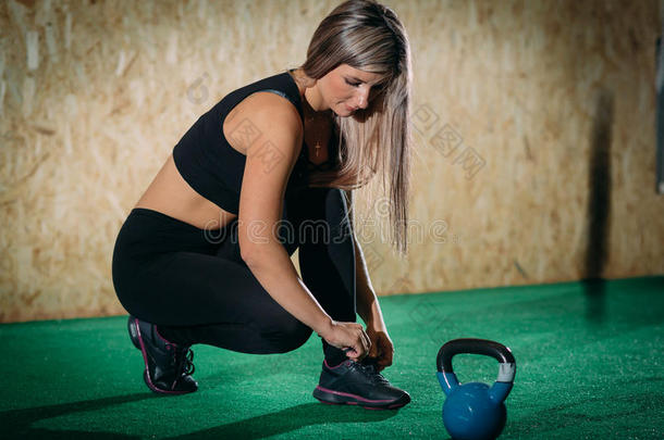女孩结在上面鞋带在之前训练采用一健身房向一绿色的地面