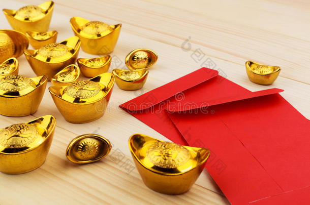 金中国人铸块和空白的红色的信封向木制的背景