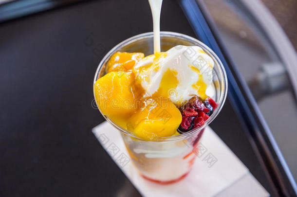 美味的芒果冰乳霜圣代冰淇淋采用塑料制品杯子
