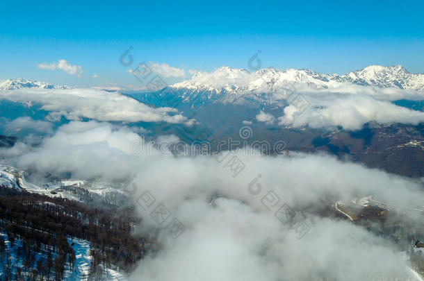 飞行的越过下雪的山,森林和滑雪跟踪采用雾