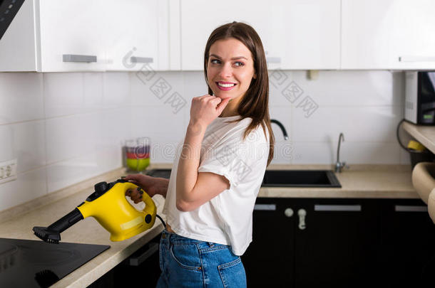 女人清洁厨房和蒸汽清洁剂