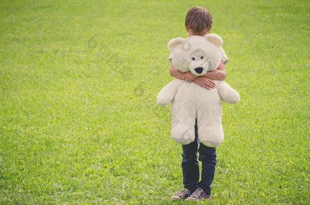 悲哀的男孩拥抱他的妇女连衫衬裤熊
