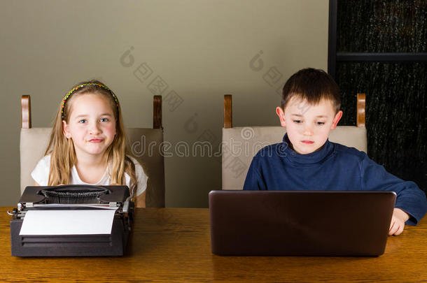 小孩工作的向老的打字机和便携式电脑