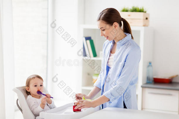 母亲和婴儿和勺吃浓汤在家