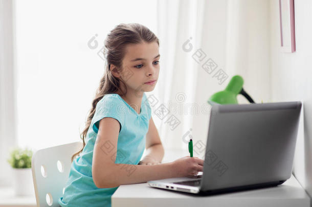 女孩和便携式电脑<strong>文字</strong>向笔记簿在家