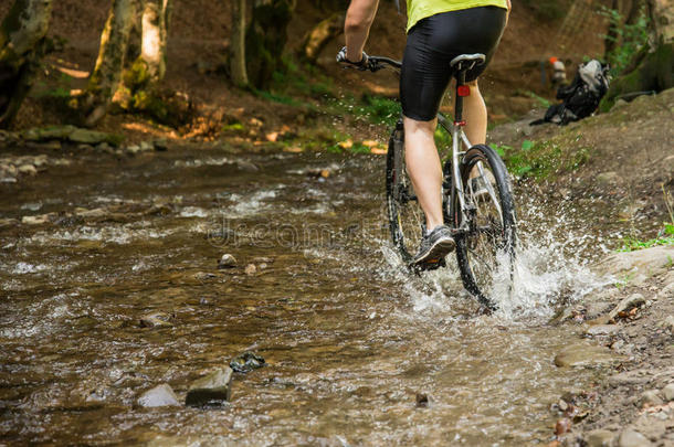 山骑自行车的人超速行驶通过森林河流