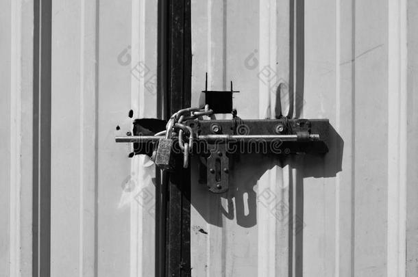上锁的挂锁和装链的向刺激金属纸门,黑的