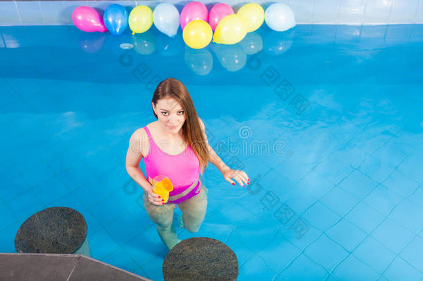 女孩和鸡尾酒喝令人轻松的在游泳水池