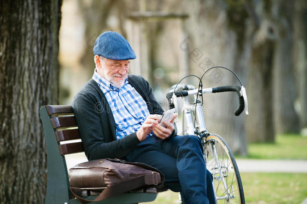 较高的男人和自行车采用城镇,hold采用g聪明的电话,text采用g