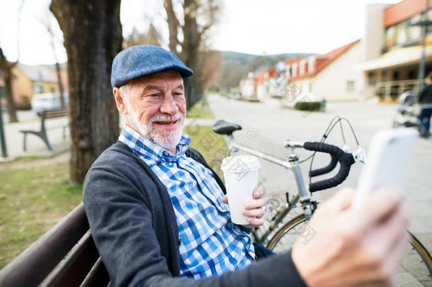 较高的男人和自行车采用城镇,tak采用g自拍照和聪明的电话
