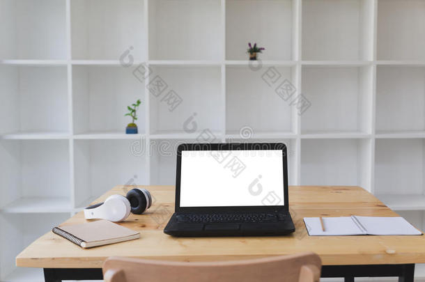 书桌表和便携式电脑,戴在头上的收话器,便条簿和白色的书架