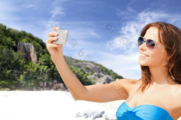 女人采用游泳衣tak采用g自拍照和手机