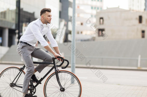 男人和耳机骑马自行车向城市大街