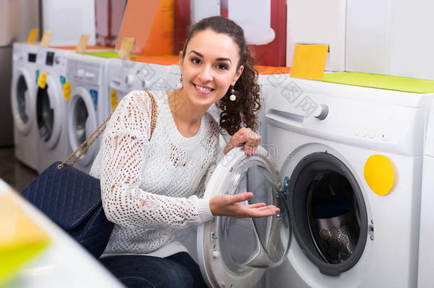 女人挑选新的洗衣店机器