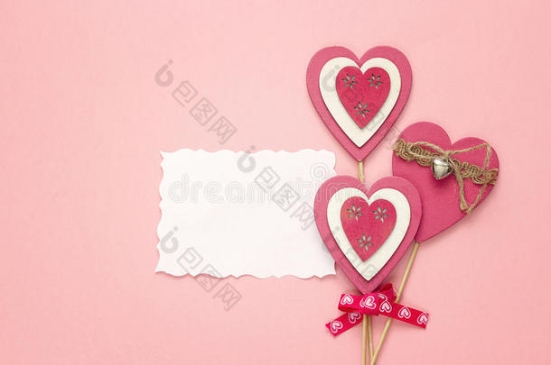空的纸卡片和装饰的心向一粉红色的b一ckground.