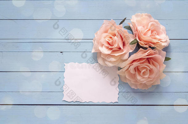背景和空白的纸卡片和粉红色的玫瑰向蓝色木制的英语字母表的第16个字母