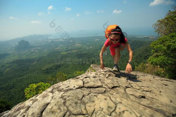 女人登山者攀登的岩石在山顶