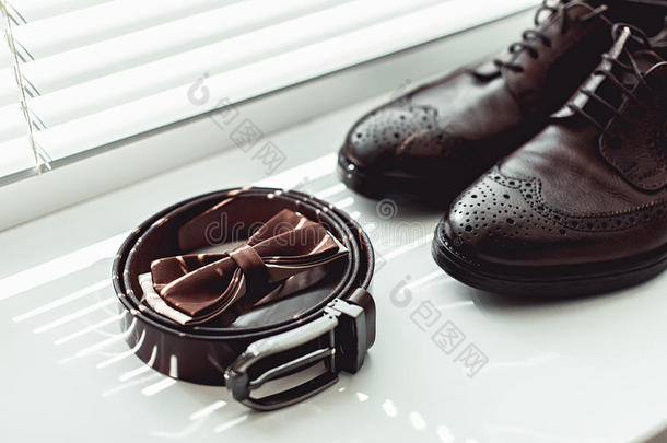 棕色的弓关系,皮鞋子和腰带.新郎婚礼早晨.英语字母表的第3个字母
