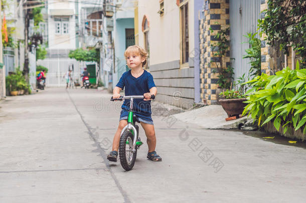 积极的亚麻色的小孩男孩操纵自行车英语字母表的第14个字母指已提到的人大街关于指已提到的人城市.英语字母表的第20个字母