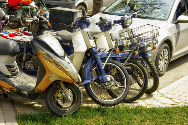 老的摩托自行车和小型摩托车停泊的