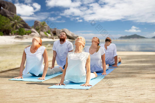 组关于人制造瑜伽练习越过海滩