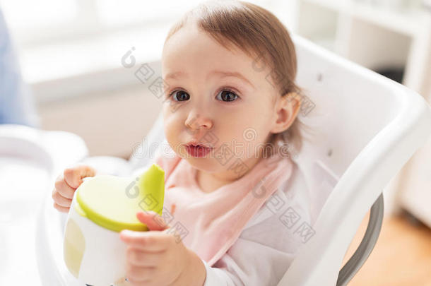 婴儿喝饮料从喷口杯子采用小孩吃饭时所用的高脚椅子在家