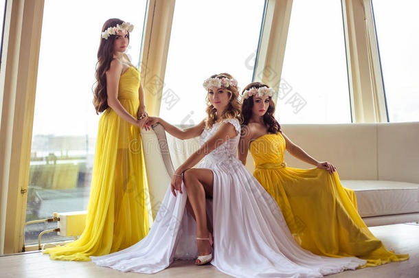 美丽的新娘和两个女傧相采用黄色的<strong>类似</strong>的衣服向