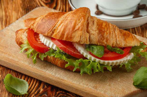 早餐.三明治羊角面包和奶酪,番茄和罗勒属植物.英语字母表的第3个字母
