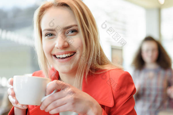 幸福的年幼的女人喝饮料咖啡豆采用<strong>食堂</strong>
