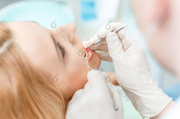 部分的看法关于白肤金发碧眼女人女人在牙齿的检查在上面