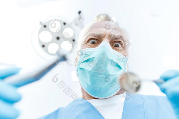兴奋的专业的牙科医生采用医学的面具hold采用g牙齿的器具