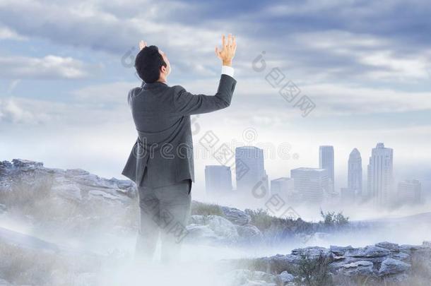 商业男人手在上面向多雾的山山峰反对地平线